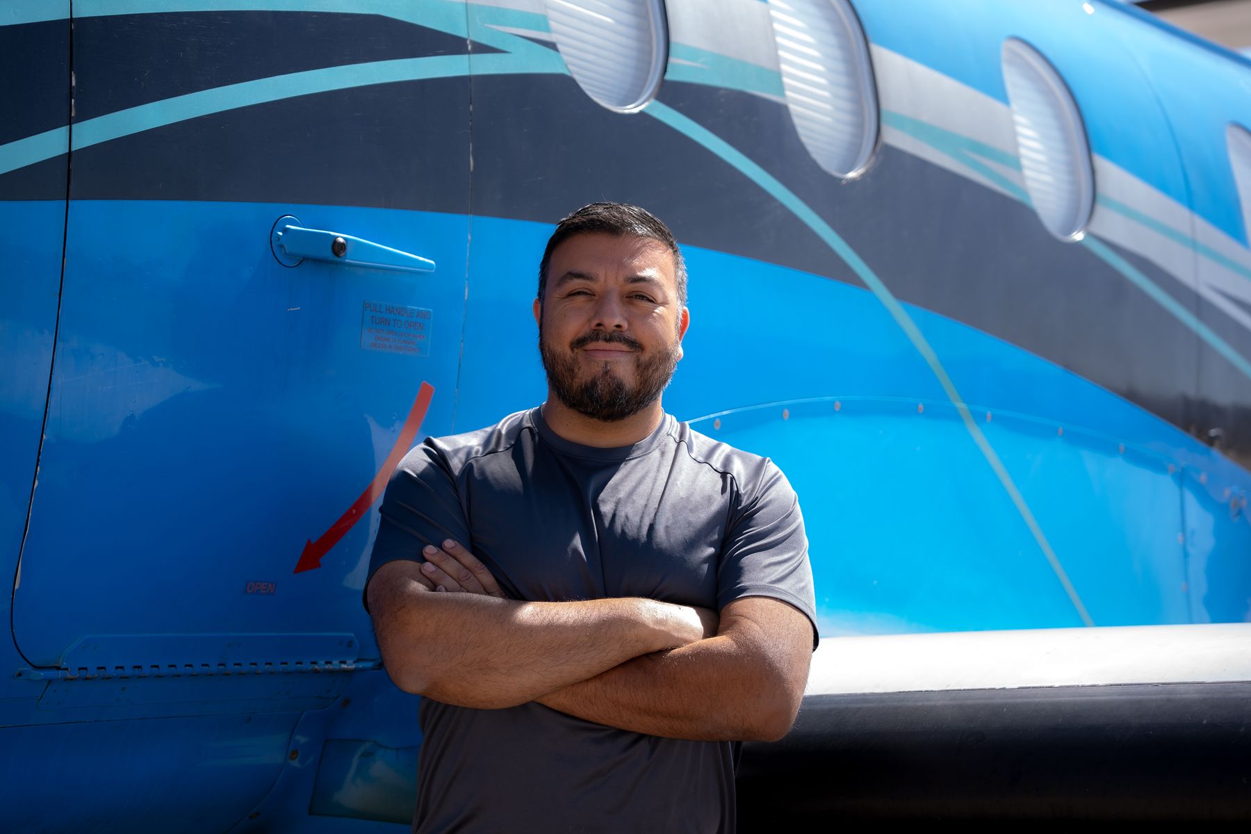Open Sky technician beside a blue turboprop
